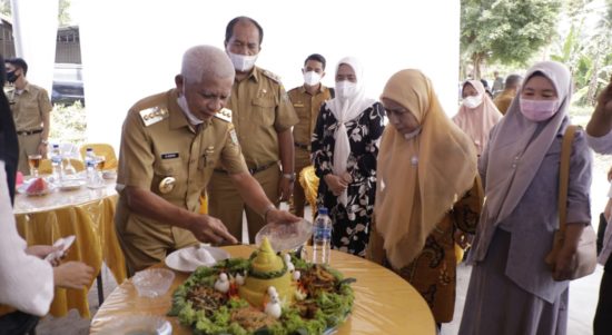 Bupati Asahan saat memotong nasi tumpeng.