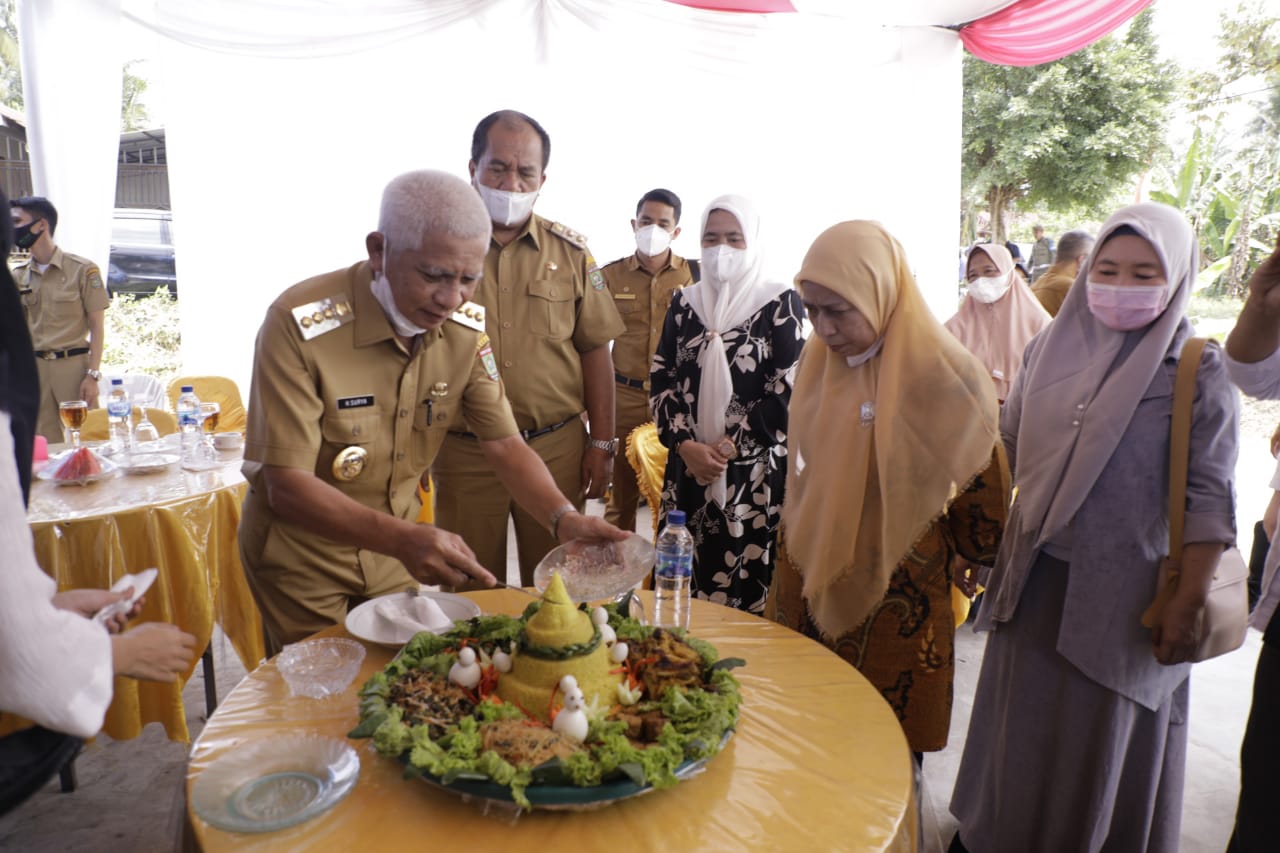 Bupati Asahan saat memotong nasi tumpeng.